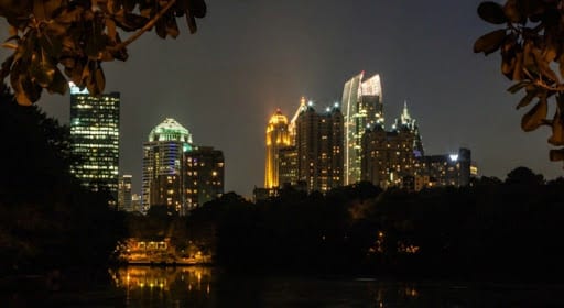 Illuminated city skyline reflecting on calm water at night